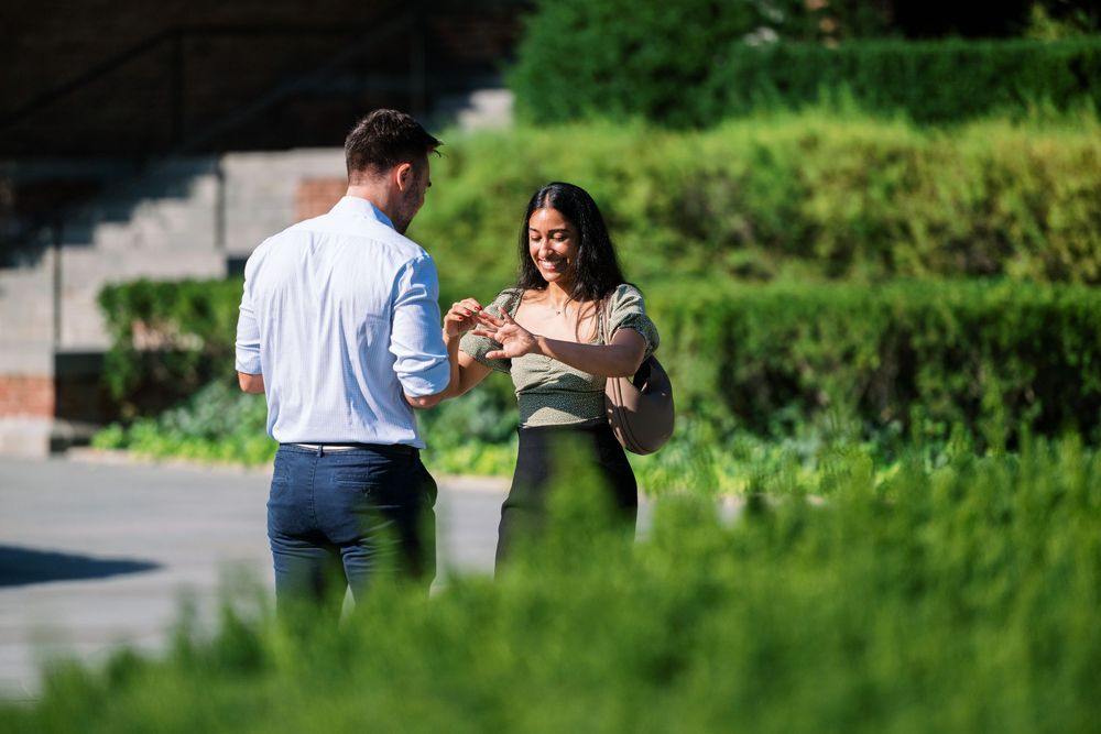A couple walking together on a path surrounded by green landscaping.