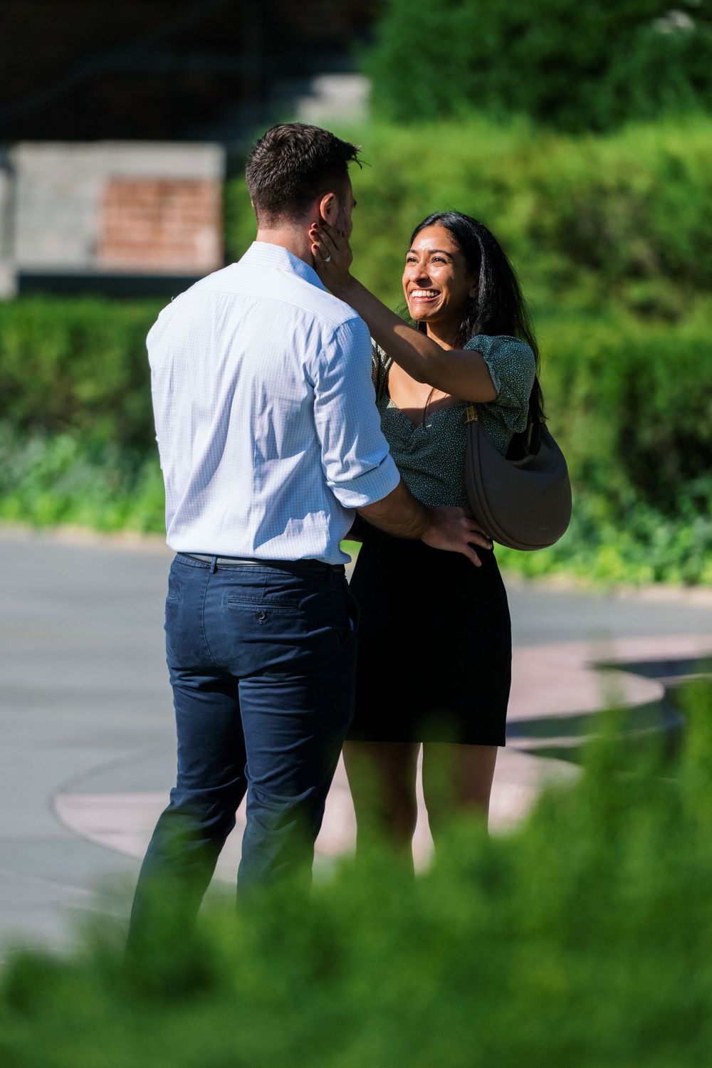 Two people strolling through a garden path on a sunny afternoon.