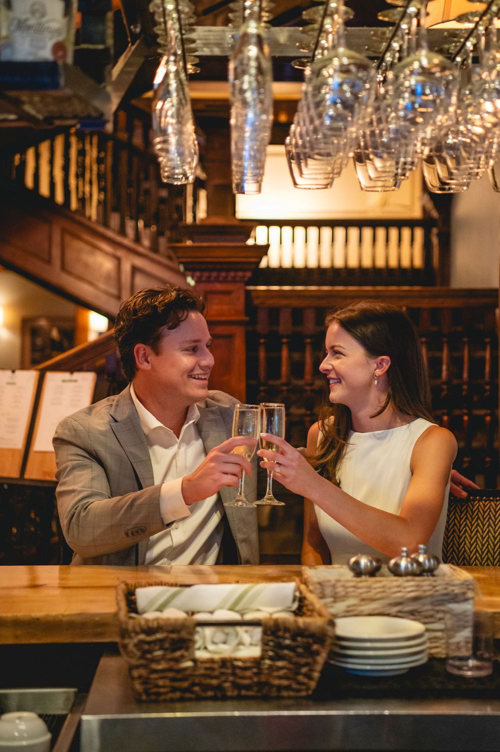 Romantic couple dining together at an elegant restaurant with warm lighting and crystal glasses.