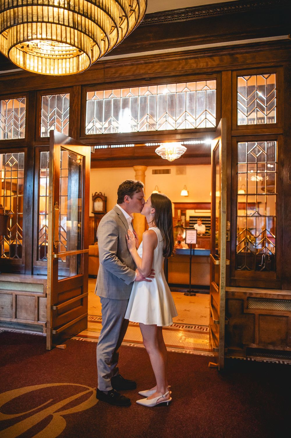 A romantic evening scene shows a couple sharing intimate moments under warm glowing lights in an elegant hotel lobby.