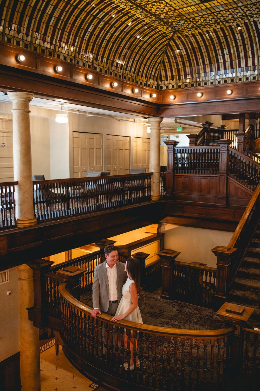 Panoramic view of a historic church interior with curved wooden balconies and ornate architectural details illuminated by warm lighting.