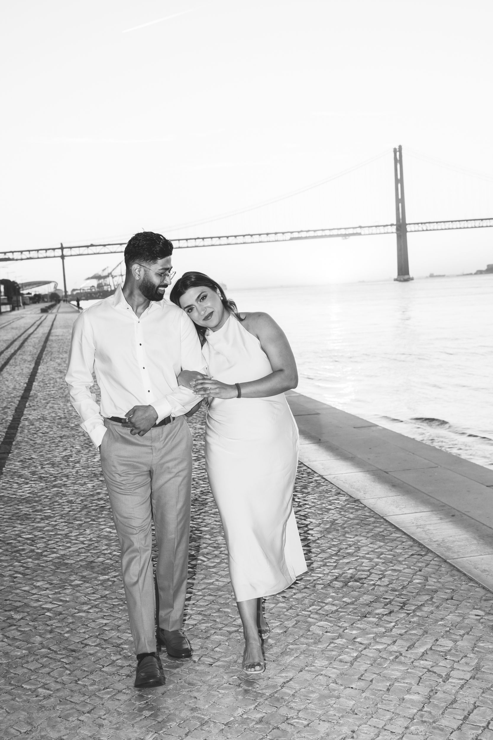 Cinematic sunrise engagement session at MAAT Lisbon — couple walking by the river, captured by destination wedding photographer in Portugal