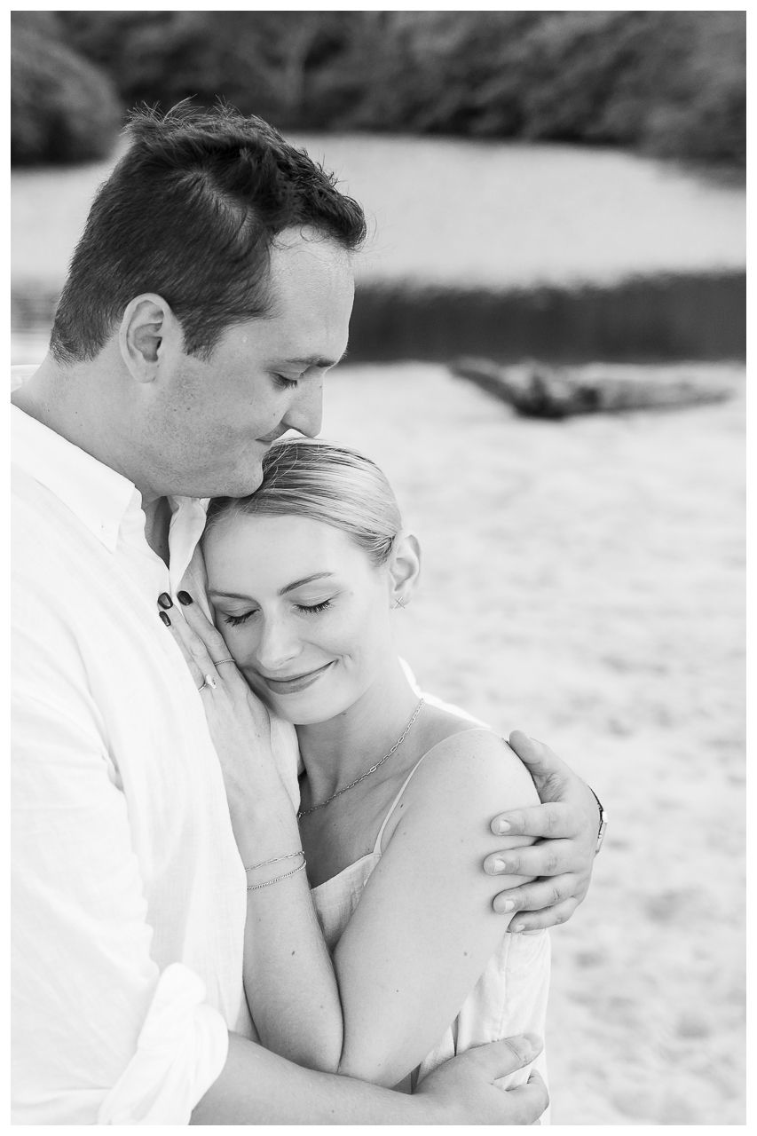 Black and white romantic beach engagement photos showing tender moments between a couple on a sunny day.