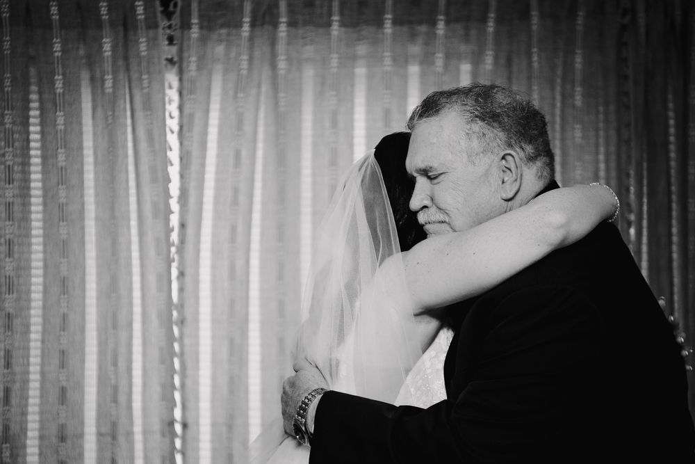A couple dancing together in a romantic embrace at what appears to be a wedding reception.