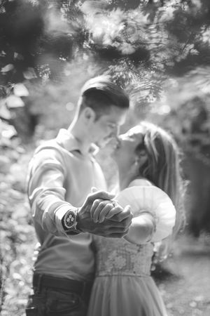 A romantic black and white photo series showing a couple embracing in an outdoor garden setting.