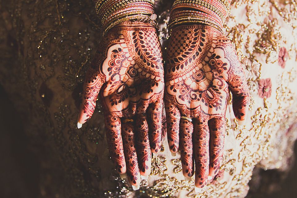 Close-up shots of hands adorned with intricate henna designs and traditional Indian bridal jewelry.
