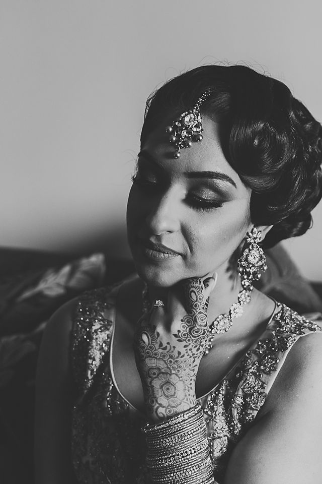 Dramatic black and white portrait showcasing traditional Indian bridal jewelry and makeup.