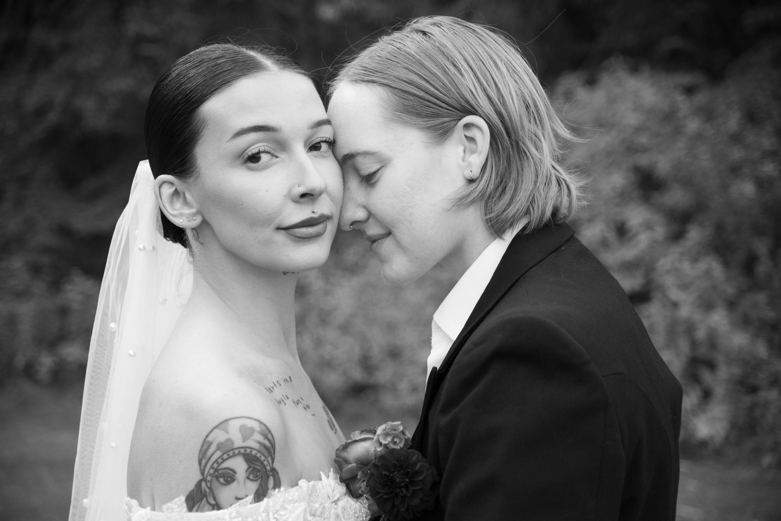 An intimate black and white wedding portrait showing a tender moment between newlyweds.