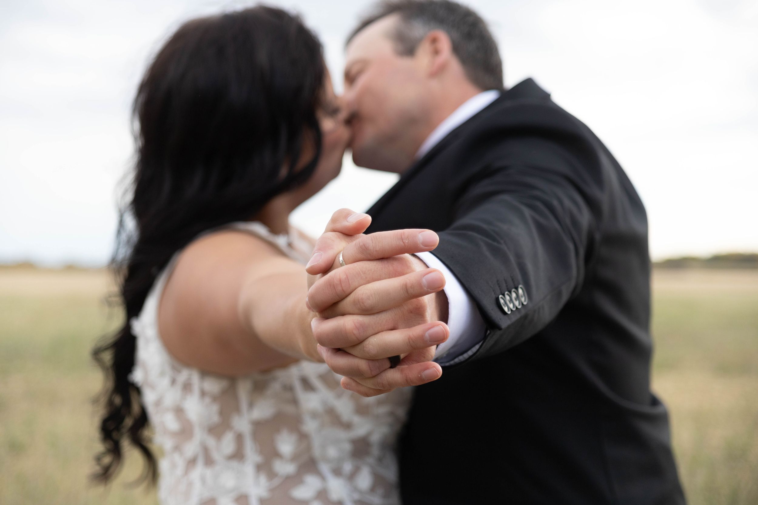 Close-up shot of newlyweds sharing an intimate dance moment outdoors.
