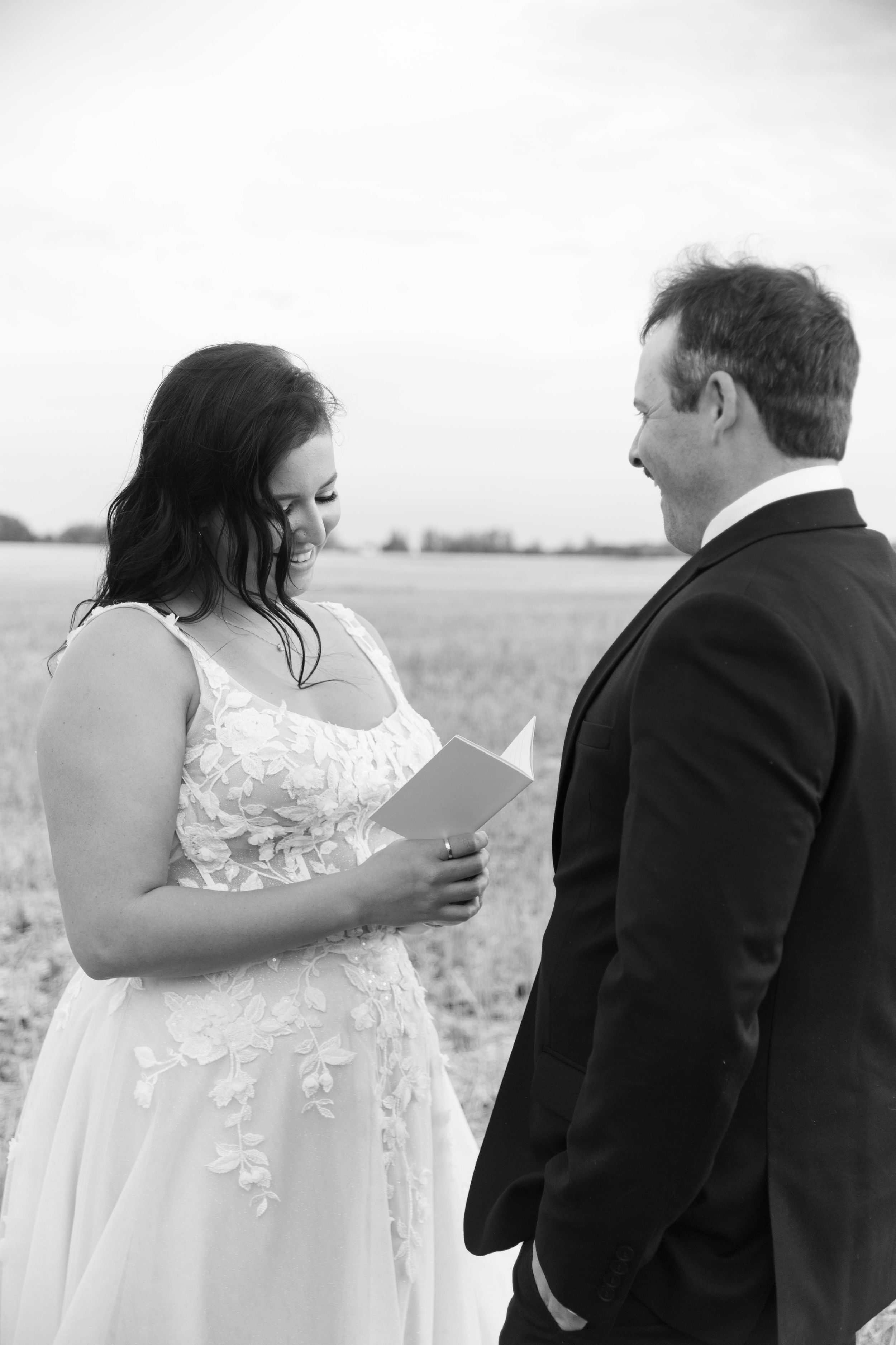A couple shares a moment while reading during their outdoor wedding ceremony.