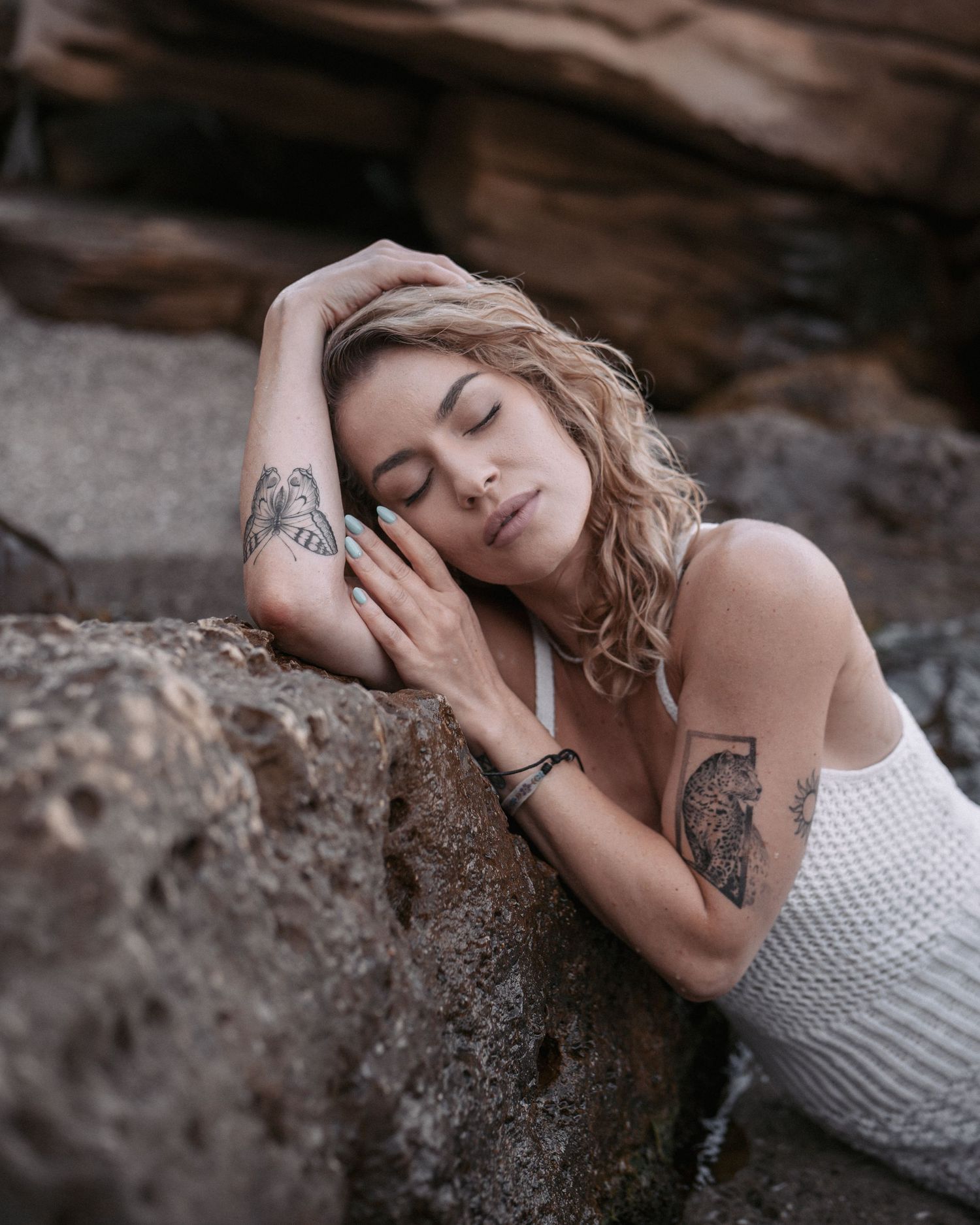 Artistic boudoir photography sequence showing subject resting on textured rock surface.