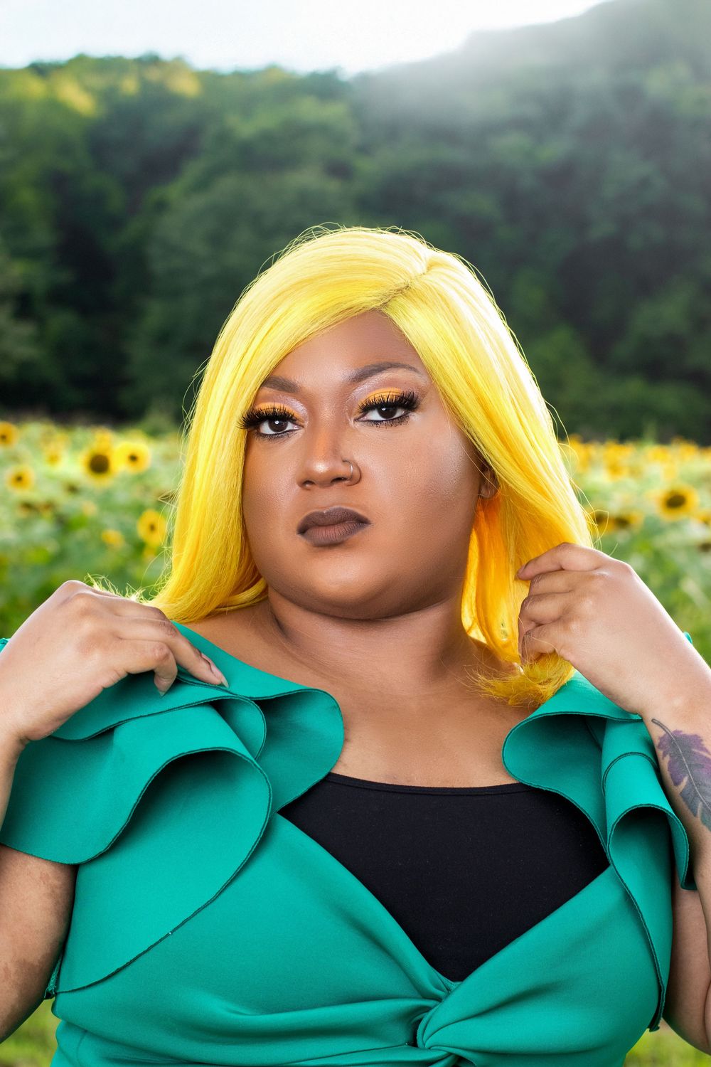Photo of a woman with yellow hair, posing in front of a sunflower field in Mobile, Alabama.