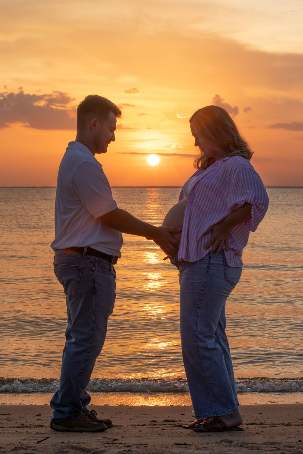 Sunset photo of expecting parents at the Fairhope Pier in Alabama.