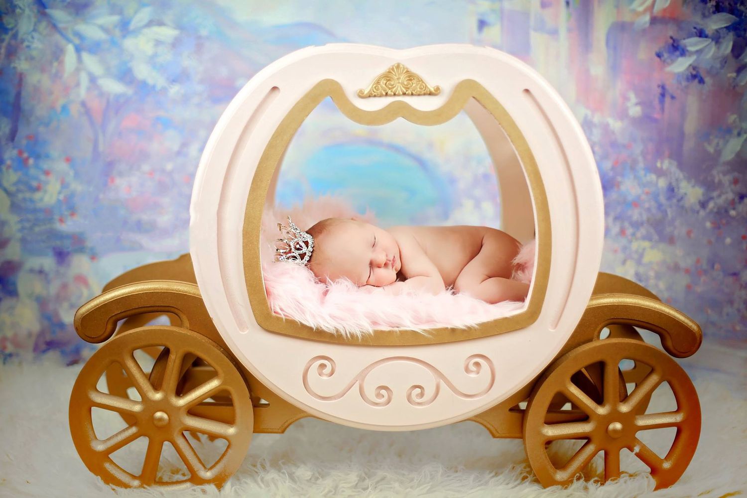 Sleeping newborn posed in ornate white carriage prop against dreamy background.