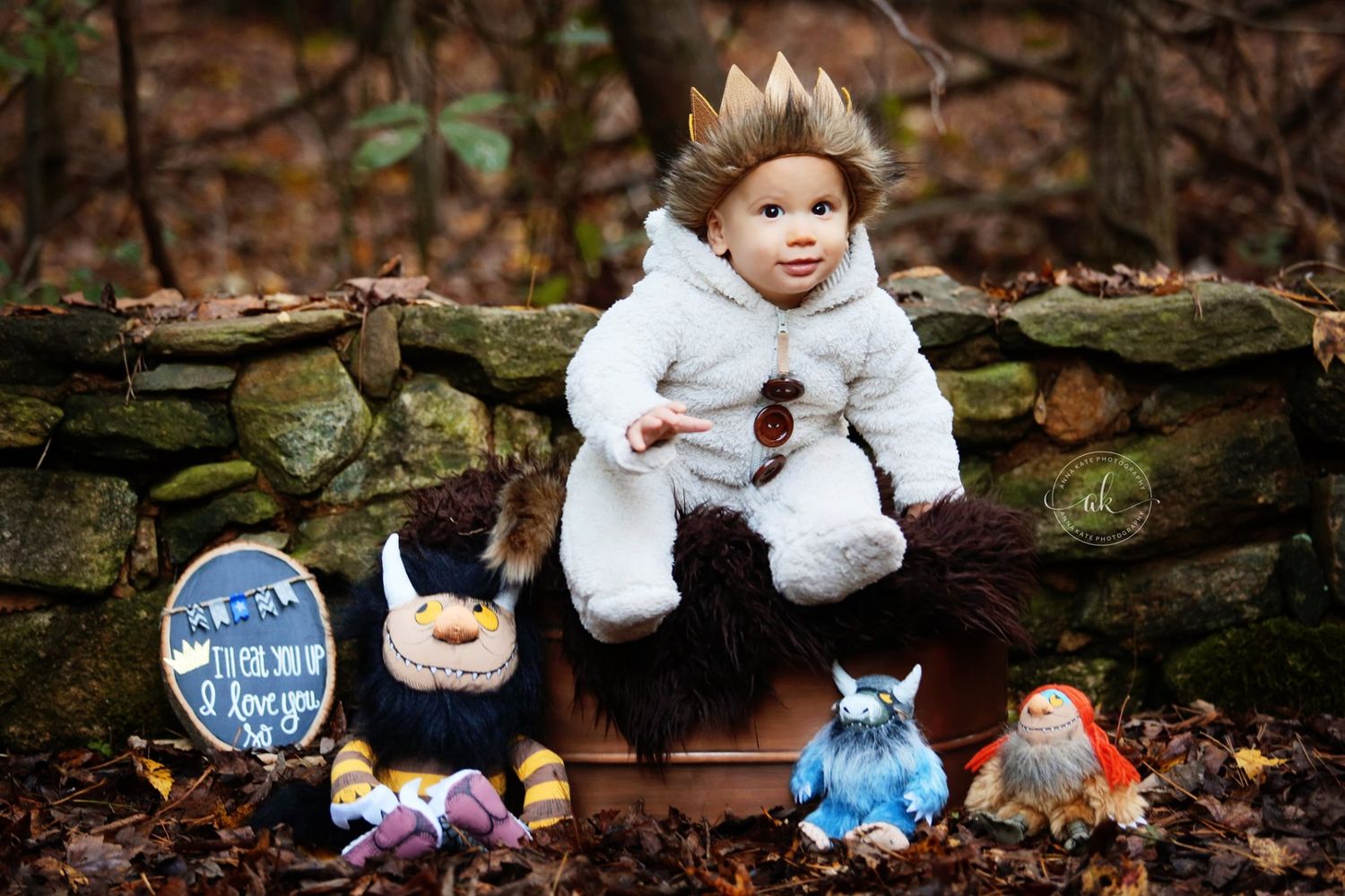 Winter themed photoshoot with plush toys and stone wall backdrop outdoors.