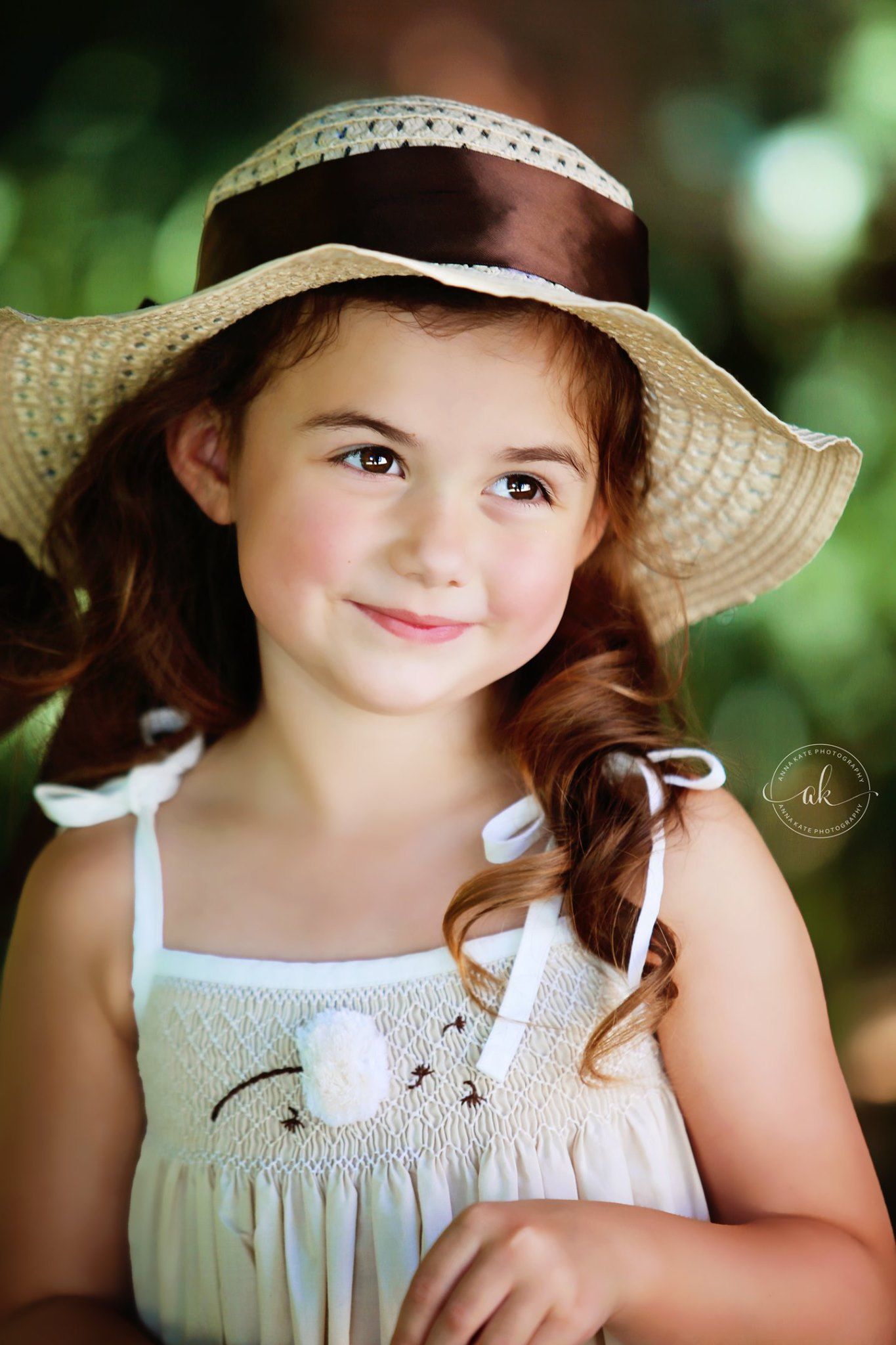 Young photographer captures portrait of child in summer dress and floppy hat in natural lighting.