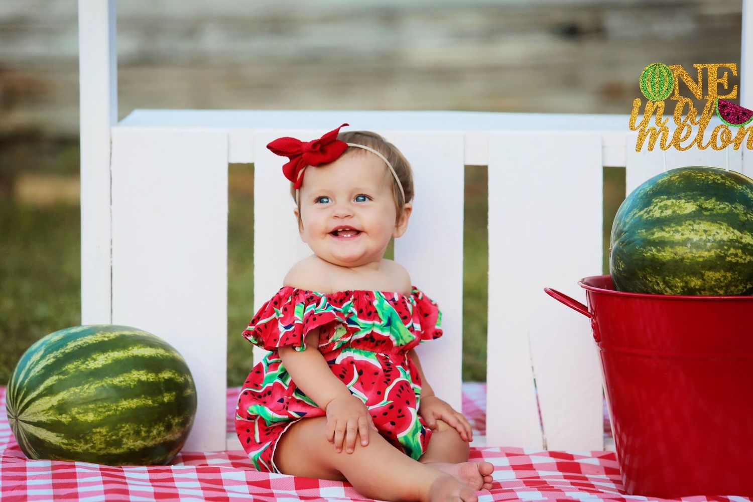 Summer themed photoshoot with watermelon print outfit and red checkered tablecloth.