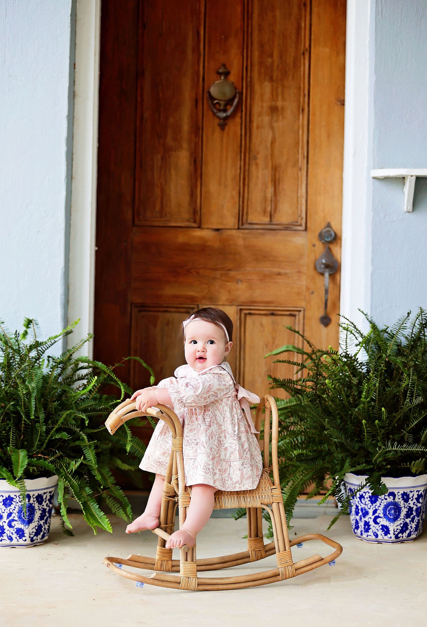 Four panel view of a vintage white doll displayed on a rustic porch with potted blue and white planters and wooden doors.