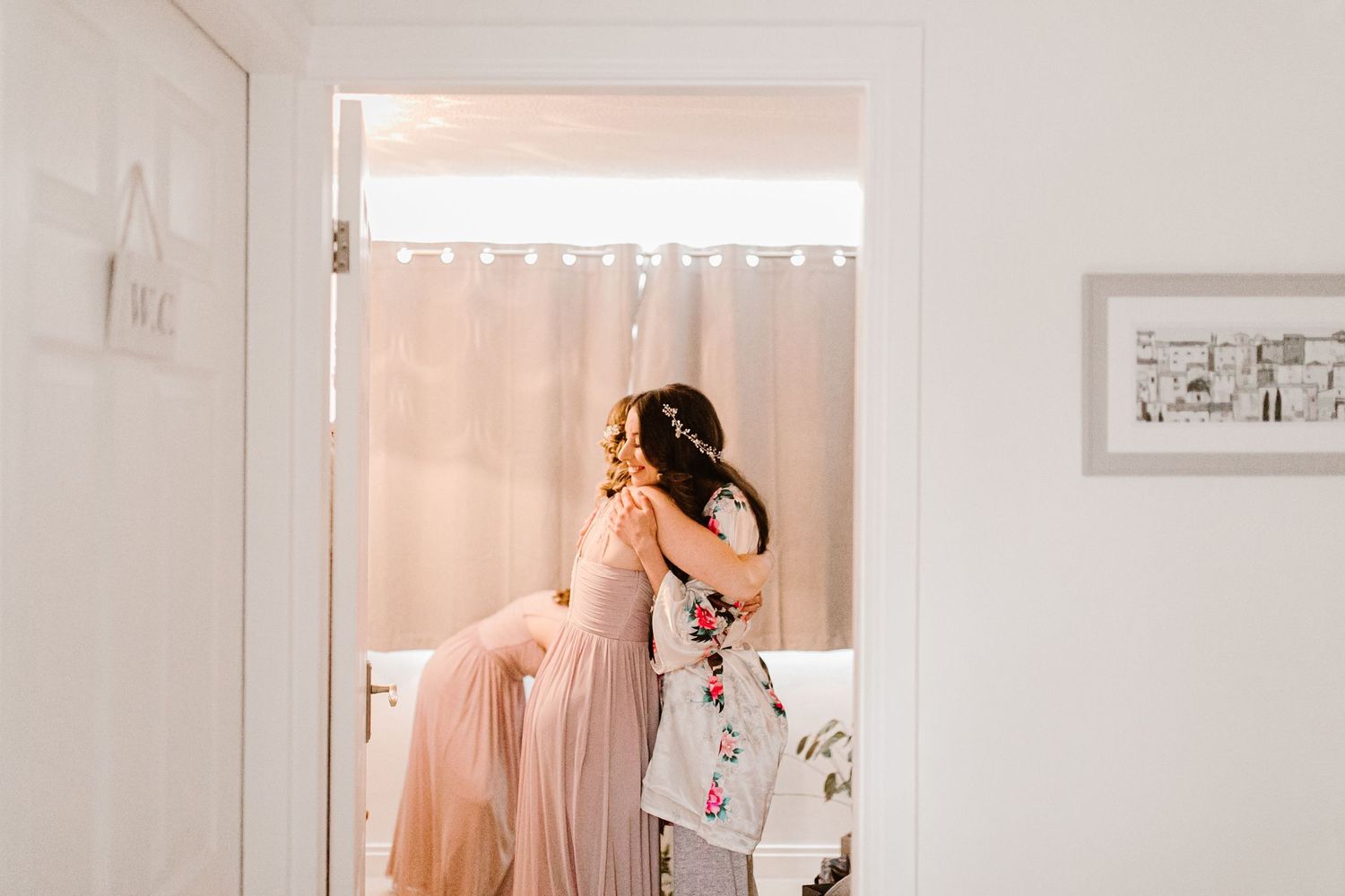 bride hugs her bridesmaid getting ready for the wedding she is smiling