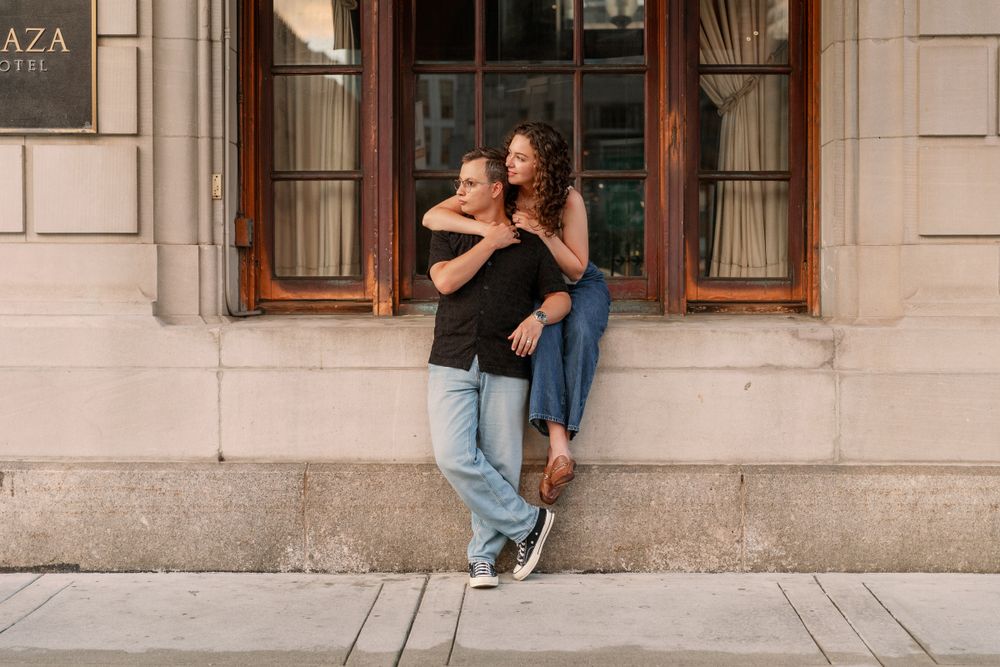 Romantic photoshoot along classic stone building with wooden windows.