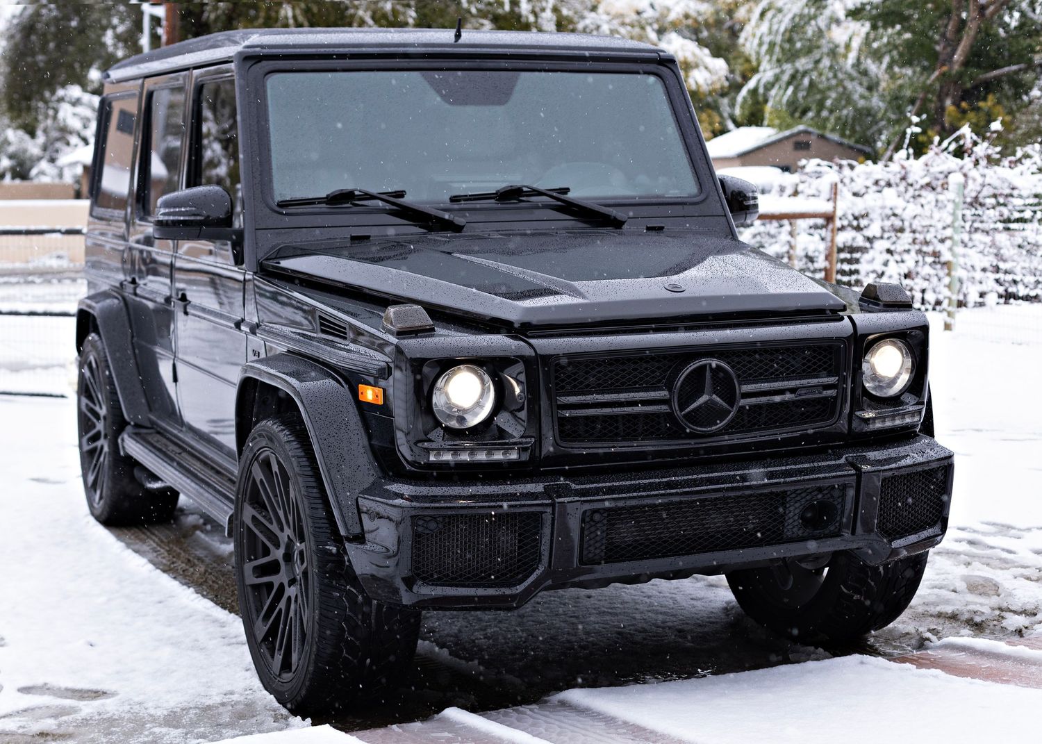 Mercedes G-Class SUV with black finish and custom wheels in winter setting.