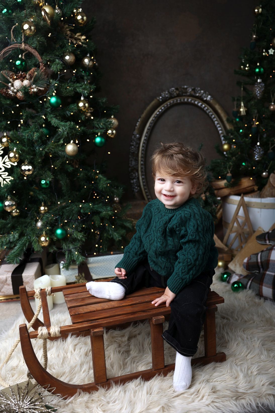 Festive Christmas scene with a wooden sleigh and decorated tree with teal and gold ornaments.