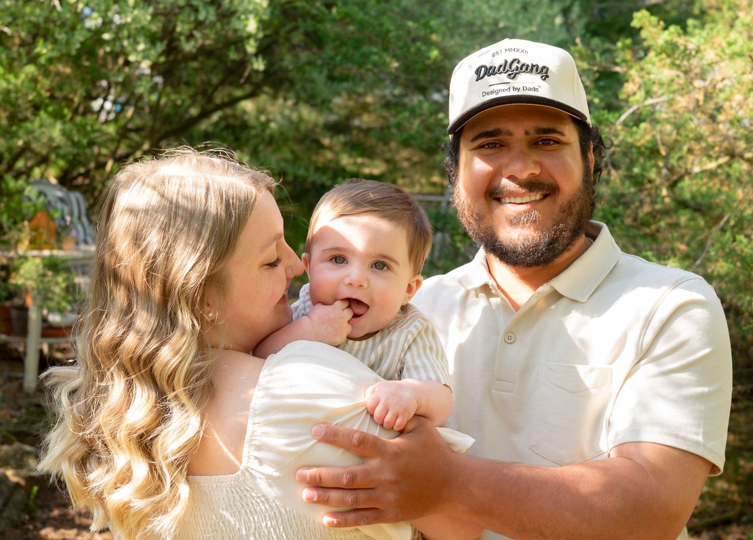 Joyful outdoor family moment captured in warm sunlight with natural greenery.