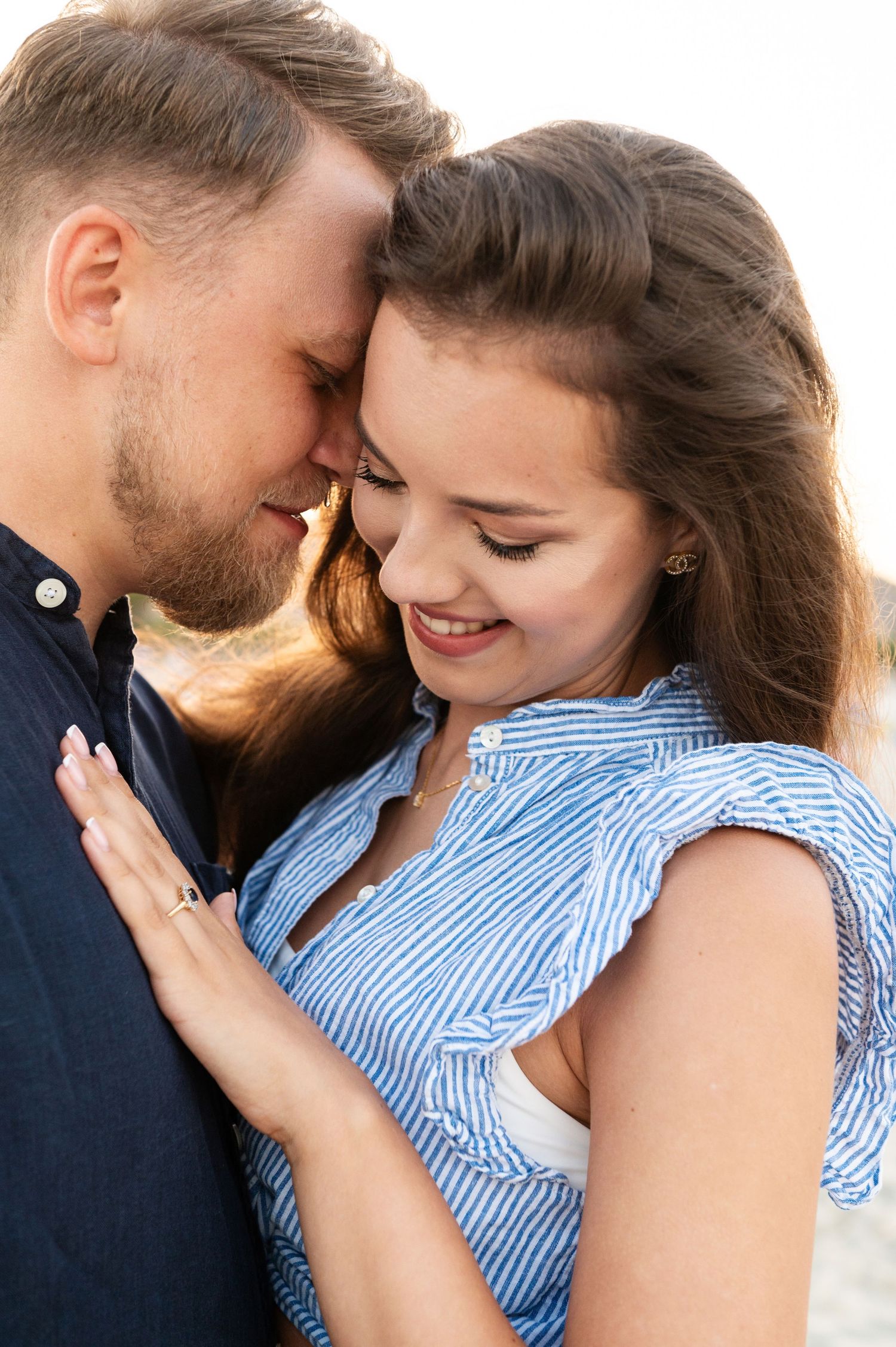 Intimate moment between couple during sunset engagement photoshoot.