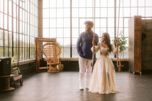 Couple in formal attire standing in a sunlit industrial loft space.