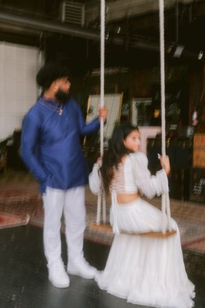 Couple posing with vintage rope swings in an industrial setting.