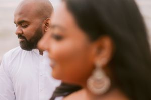 An intimate close-up portrait of a couple in soft lighting against a blurred background.