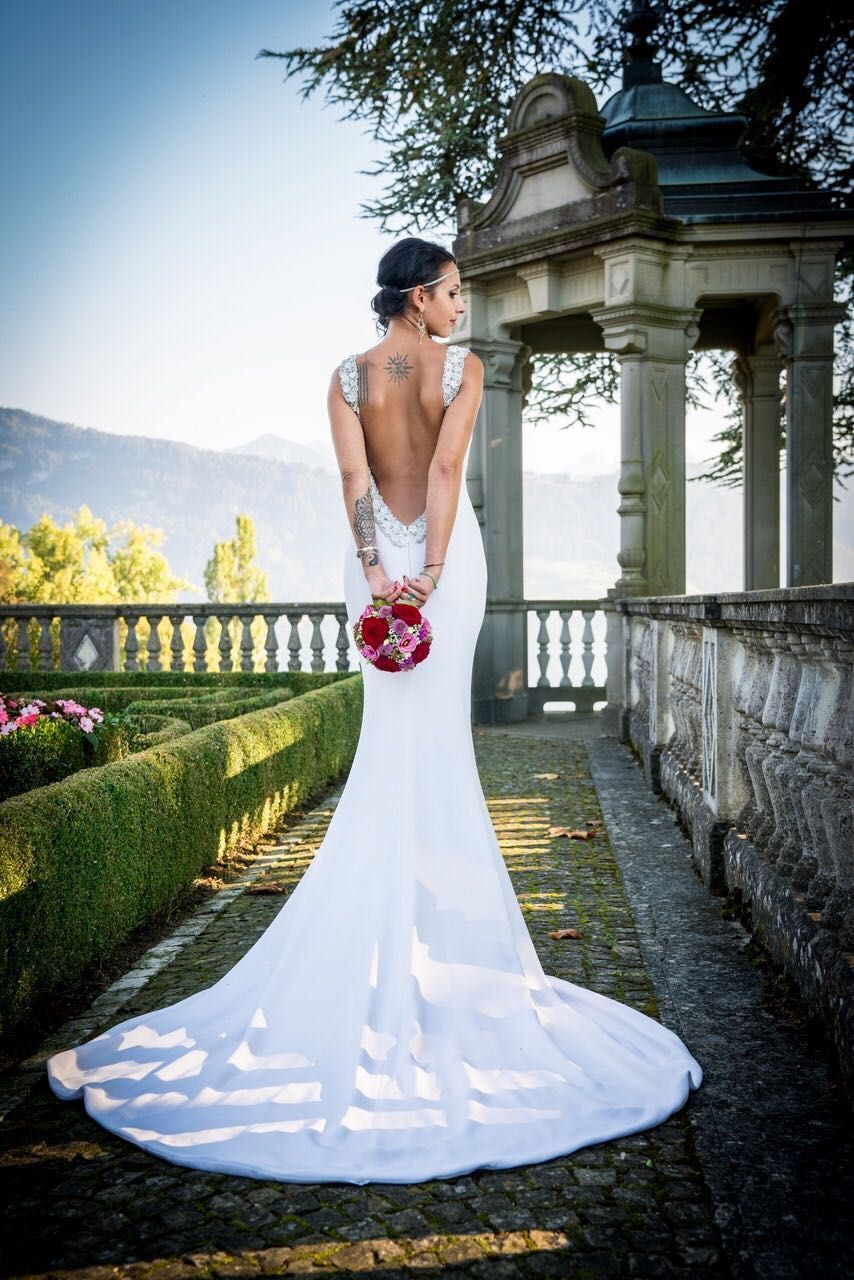 Rückenansicht einer Braut in einem langes Hochzeitskleid aus Seide mit einer langen Schleppe