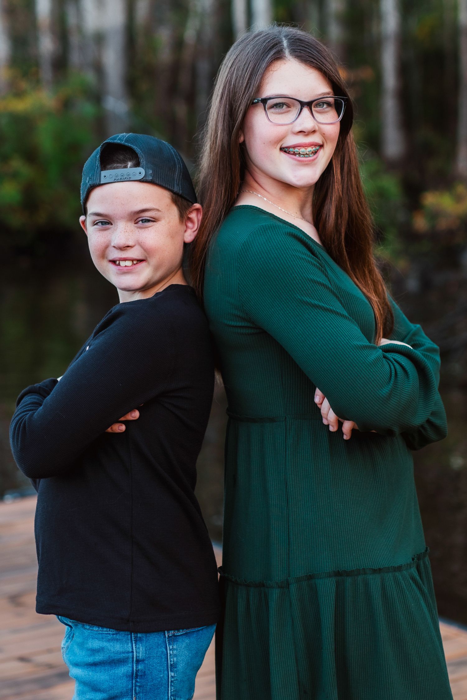 Siblings portrait, embracing and smiling in a park setting.