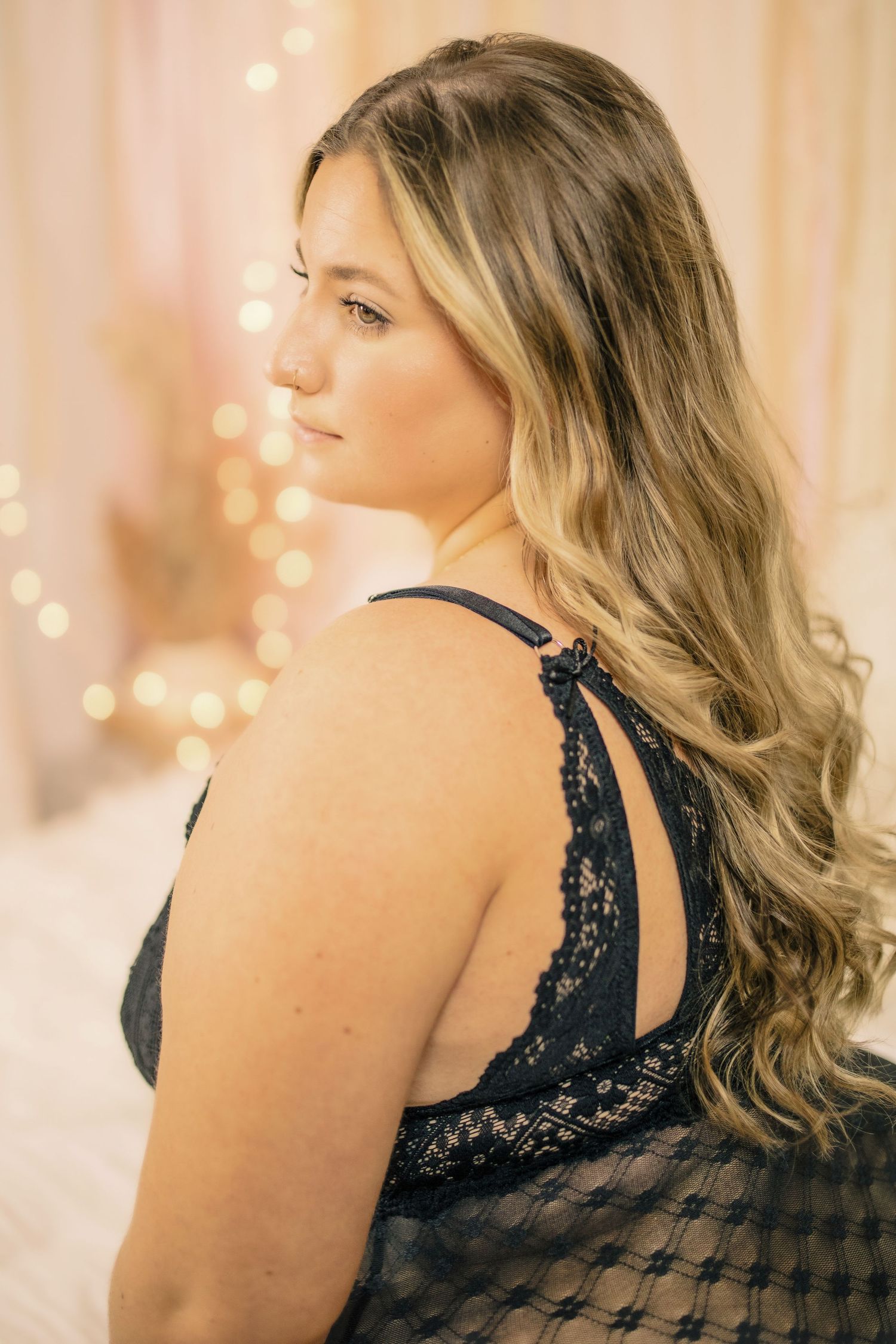 Self-love studio portrait of a curvy woman with long blonde hair, graceful pose in black lingerie with soft pastel lighting, Amherstburg.