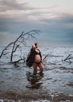 Maternity woman standing in water for maternity photo. Captured by Maryland Photographer Mallory Bramlett.