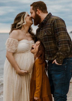 maternity woman with family on beach for maternity session. Captured by Maryland maternity Photographer Mallory Bramlett.