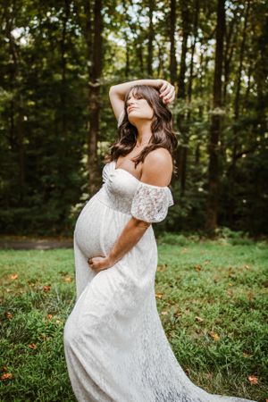Maternity woman in pretty dress for maternity photoshoot. Captured by southern Maryland maternity Photographer Mallory Bramlett.