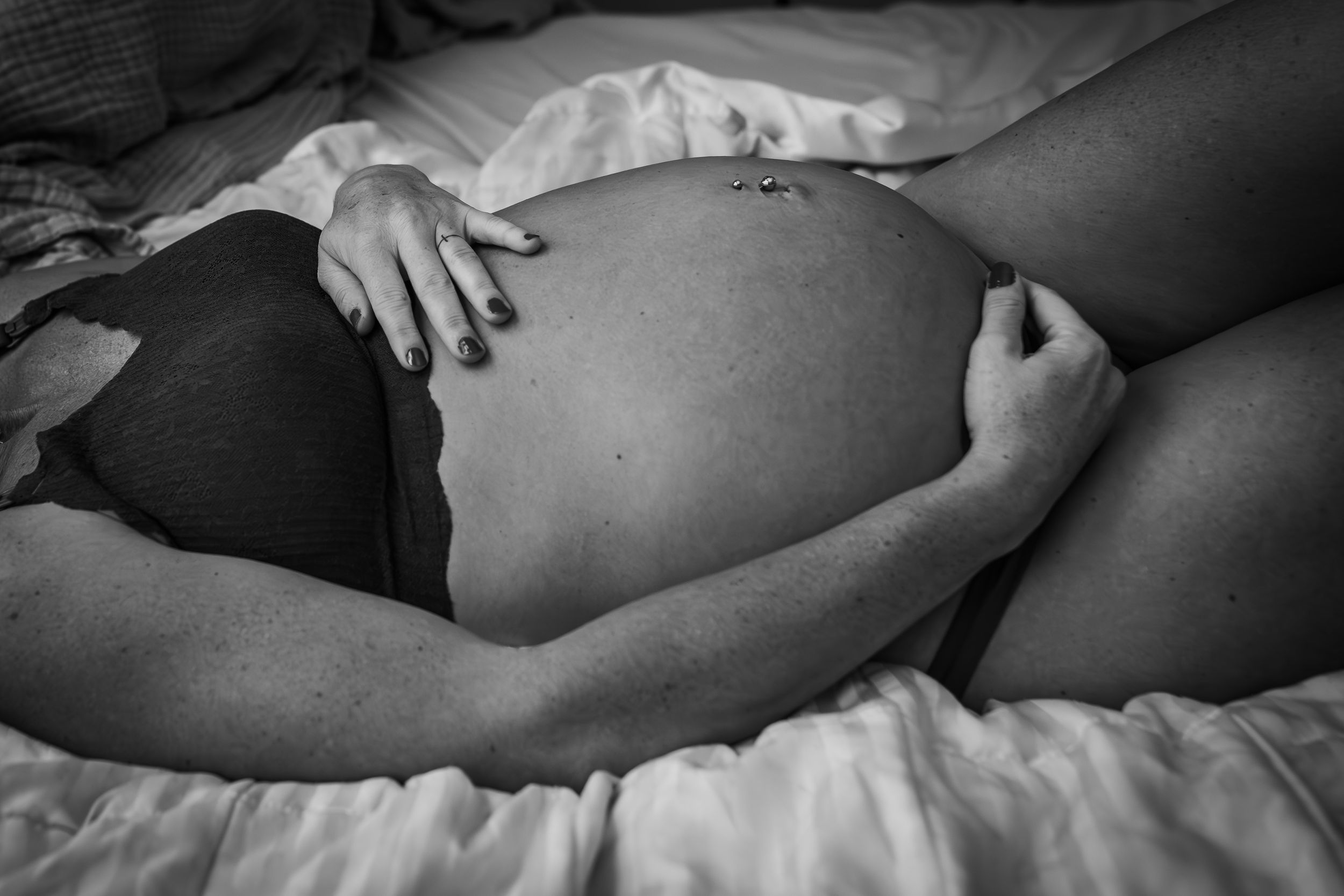 Maternity woman lying in bed for maternity portrait photography. Captured by Maryland Photographer Mallory Bramlett.