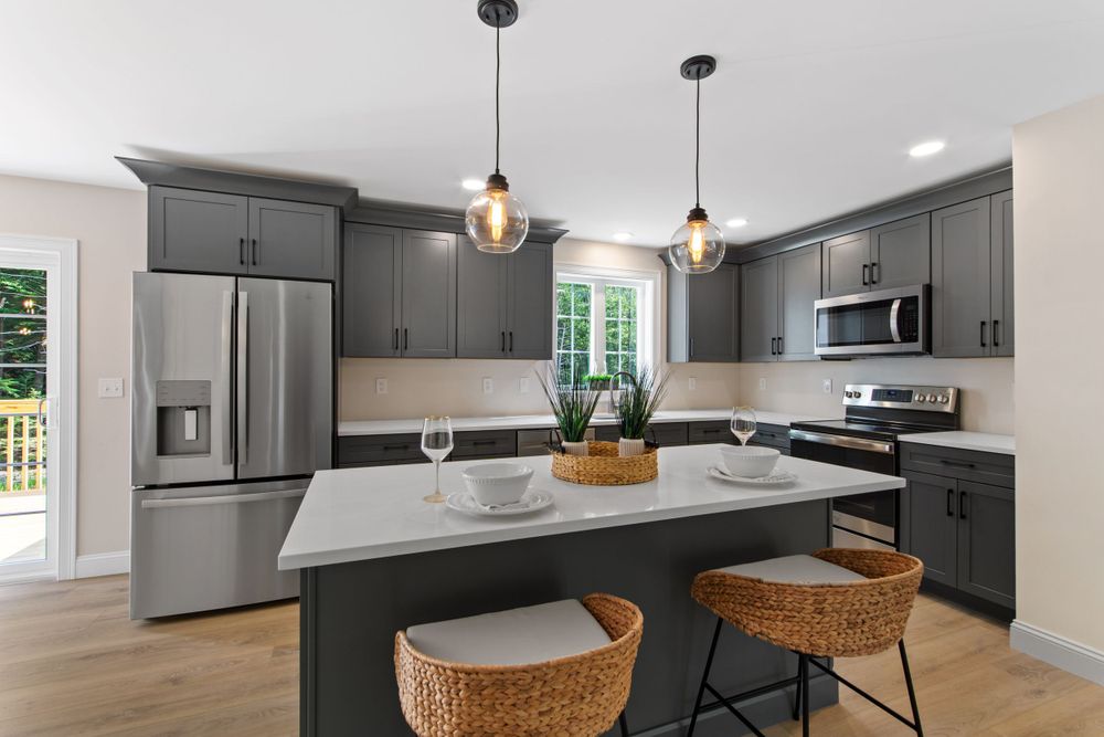 Contemporary kitchen featuring dark gray cabinets, quartz countertops, and wicker bar stools.