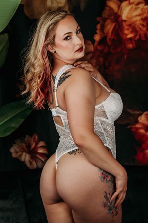 Side-angle boudoir photo showing lace lingerie and tattoo art. Grand Rapids Nice and Naughty Store Boudoir Marathon