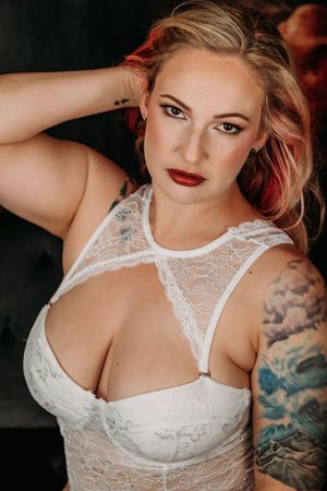 Close-up boudoir portrait with red lipstick and white lace details. Grand Rapids Nice and Naughty Store Boudoir Marathon
