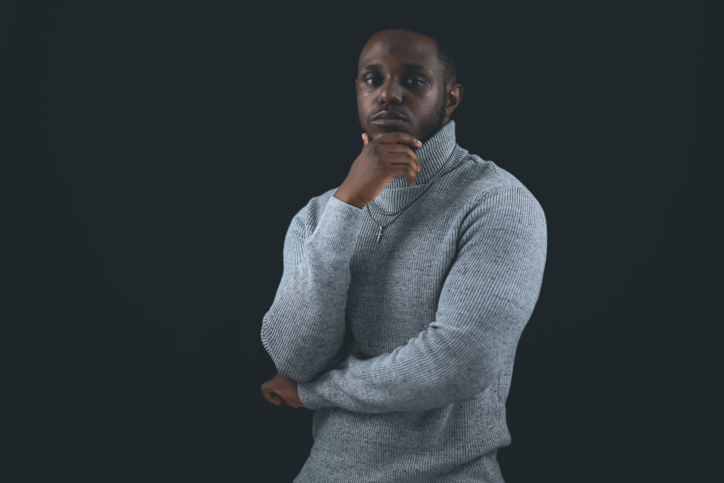 A collage of six photos shows someone in various poses wearing a grey turtleneck sweater against a dark background.
