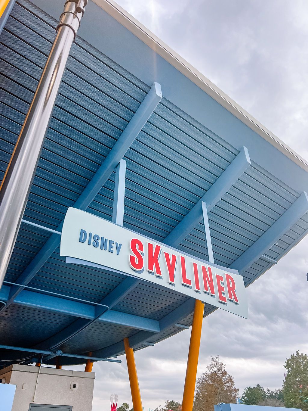 Disney Skyliner station entrance sign with blue angular architectural canopy.