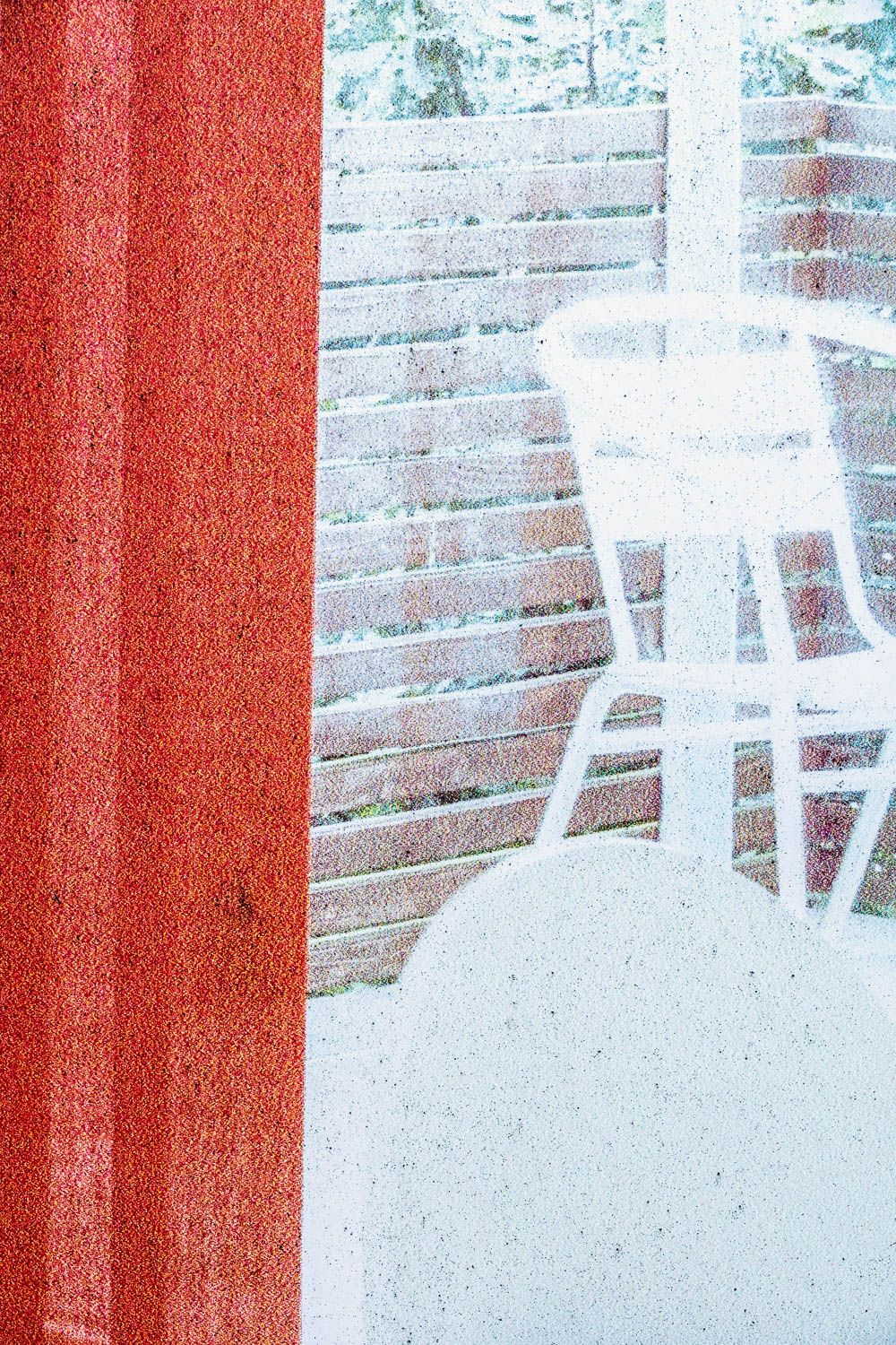 Abstract artistic photograph showing a white chair silhouette against red and white textured background.