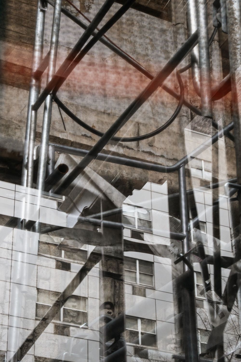 Abstract architectural detail showing metal scaffolding and white tiled walls with industrial pipes in a modern building interior.