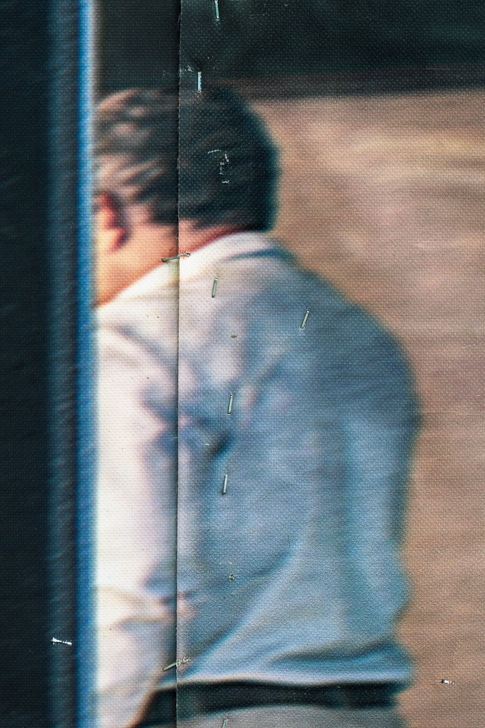 A person wearing light colored clothing appears blurred as they walk from right to left across the frame.