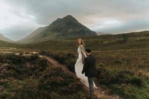 Scottish Highlands landscape with sweeping mountain vistas and dramatic moody skies over rugged terrain.