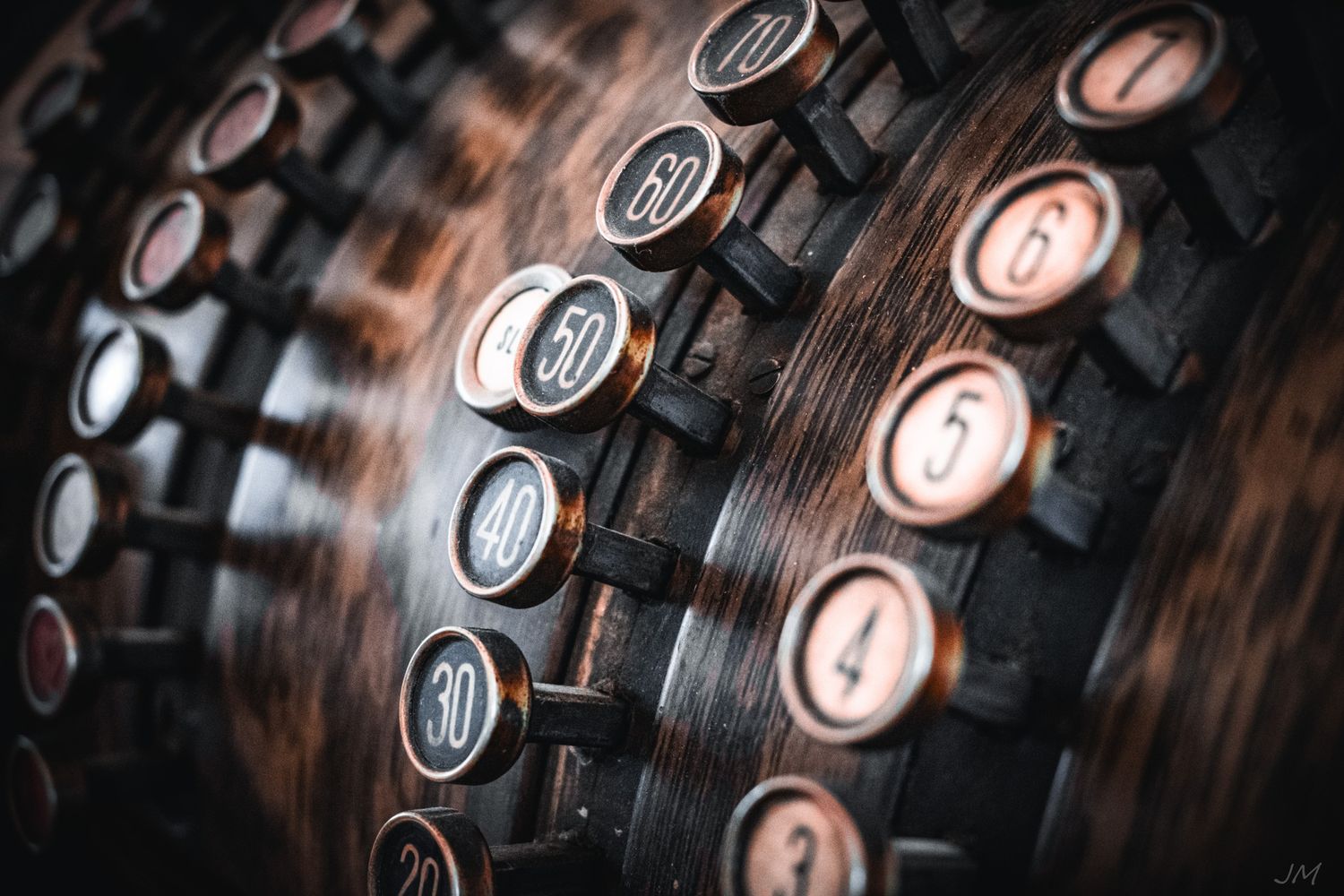 Close-up of vintage numerical keys on an antique machine with shallow depth of field.