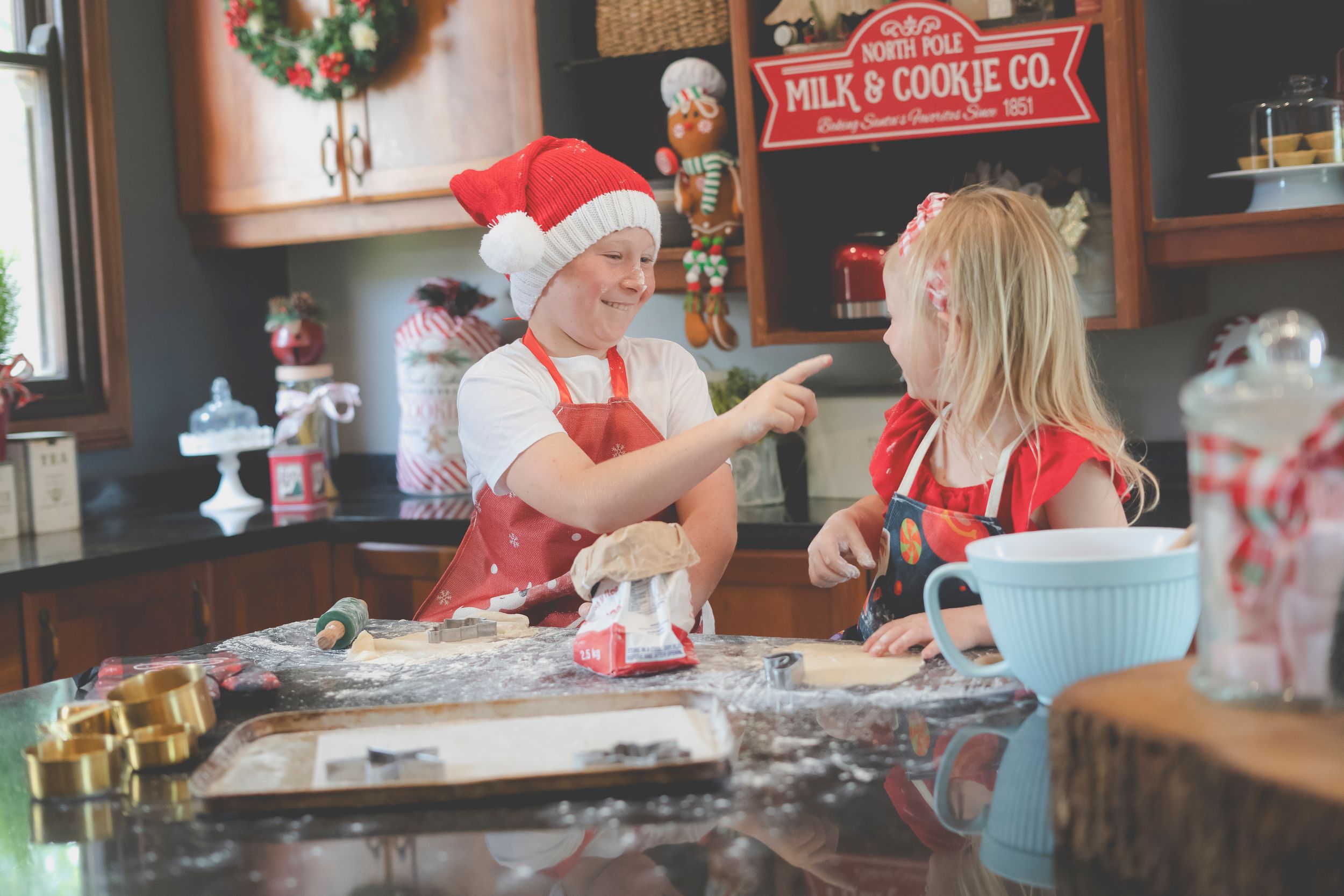 A Christmas baking scene with a brother and sister having a baking flour fights
