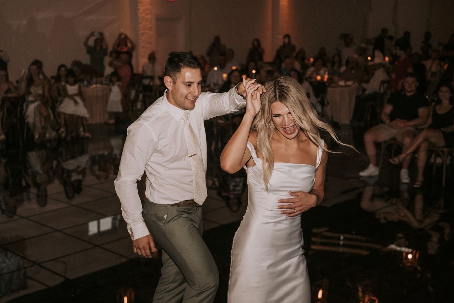 A couple dances together on their wedding night at D’Venue in Albuquerque while guests watch in the background. ABQ wedding photographer NM